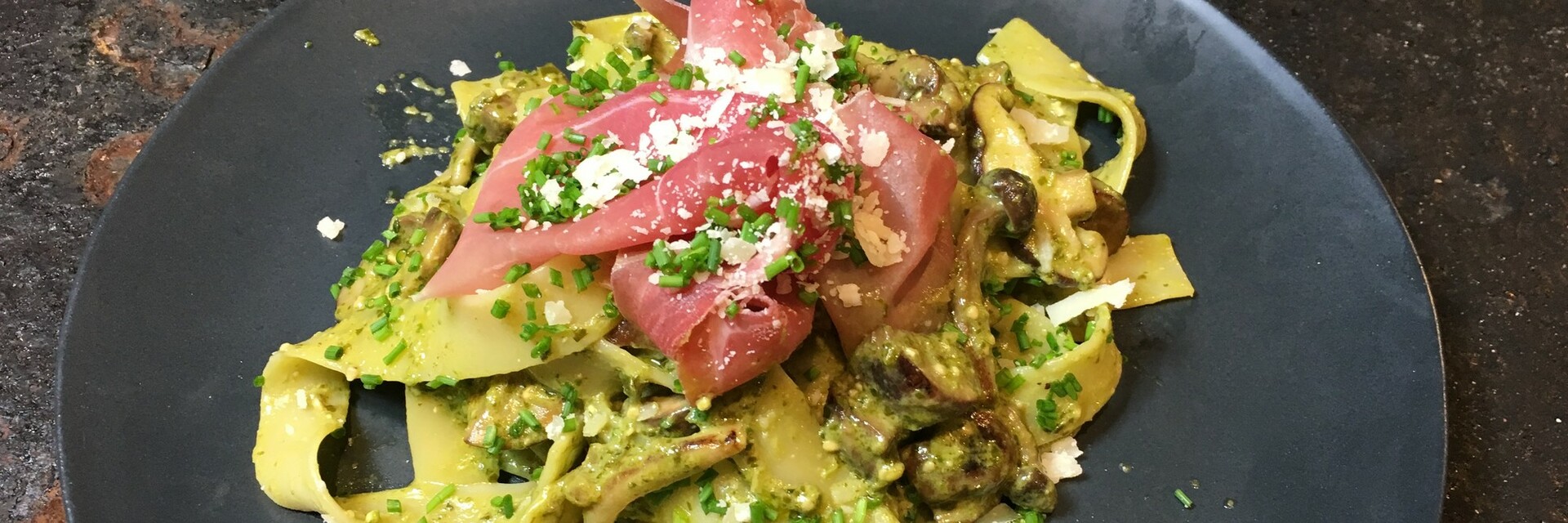 Tagliatelle met pesto, bospaddenstoelen en parmaham
